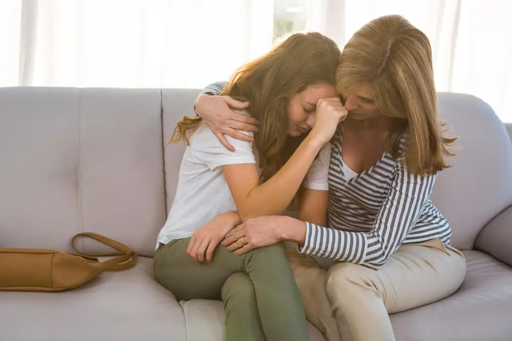 mother comforting teenage daughter